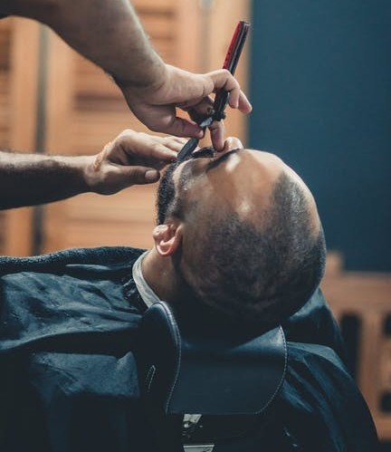 Barber using razor on client